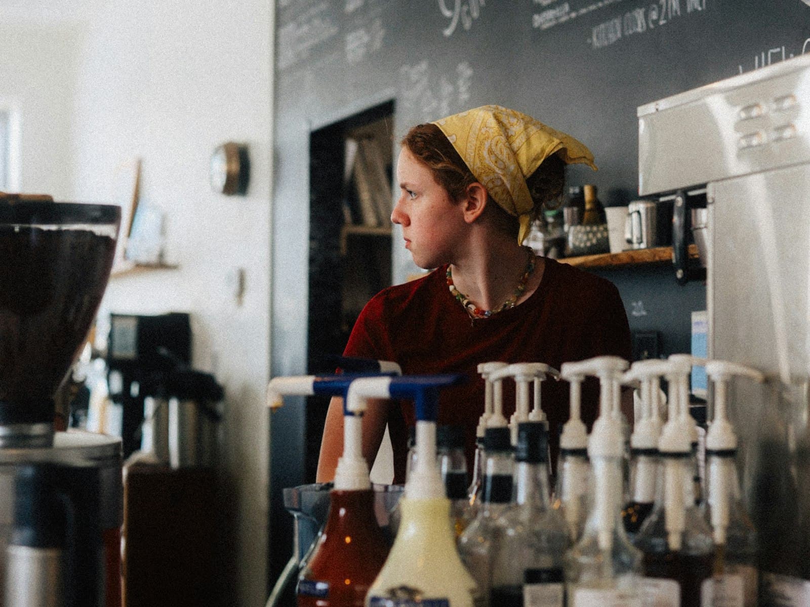 Independent cafe owner standing behind the counter of her coffee shop