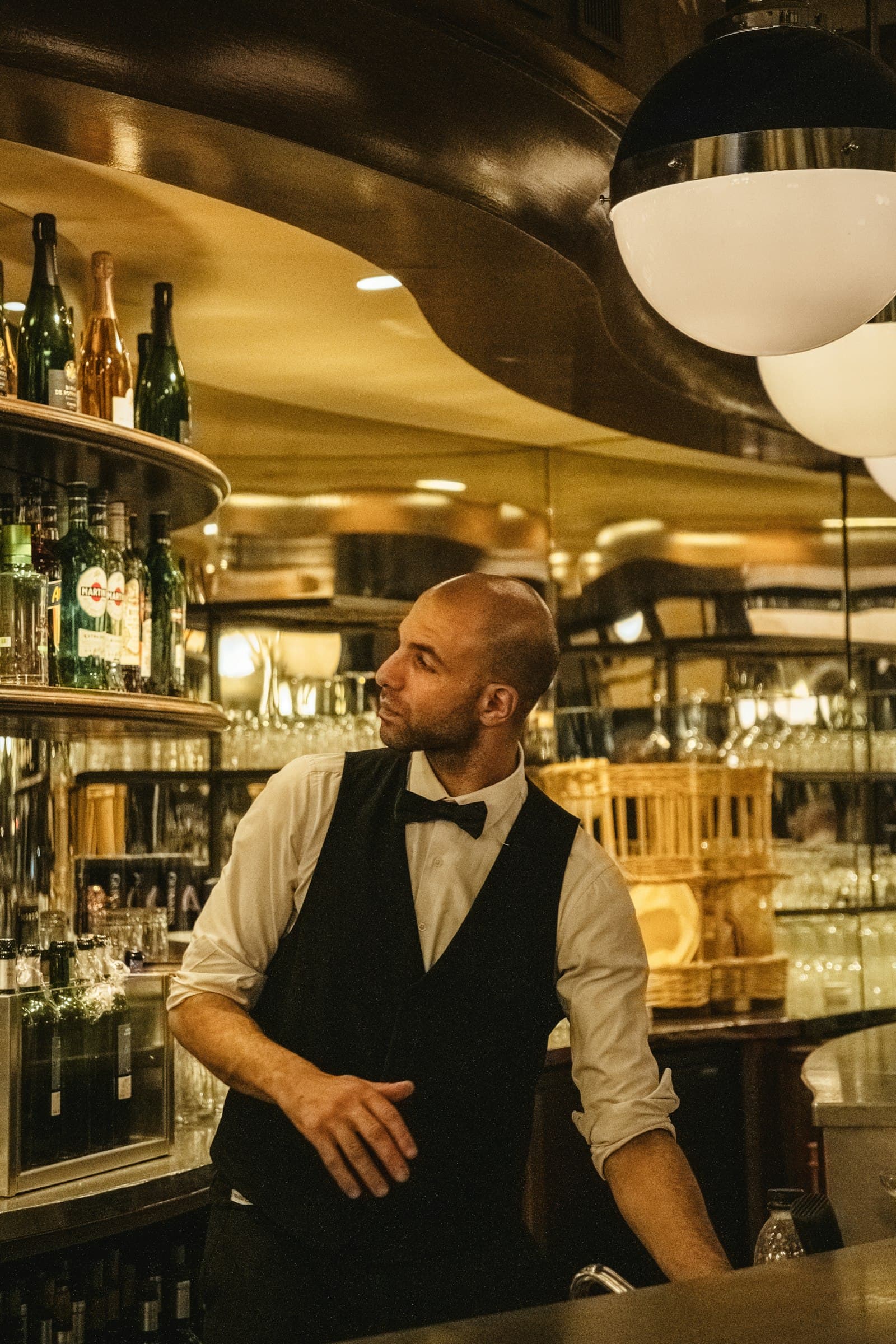 Refined host in a bow tie at the bar of an upscale restaurant in the evening